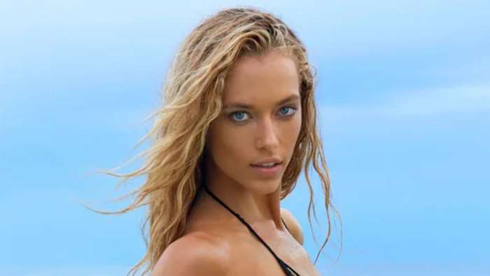 Hannah Ferguson poses in front of the blue sky in a bikini, sporting her blonde hair in a soft wave.